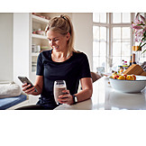   Young Woman, Smiling, Home, Reading, Smart Phone, Smoothie